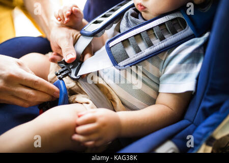 Father fastening seat belt for his son sitting in the car. Stock Photo