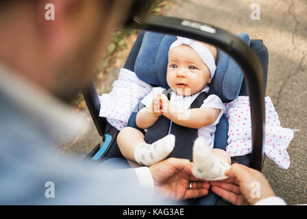 Father with baby daughter sitting in car safety seat. Stock Photo