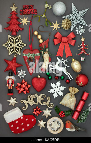 Symbols of merry christmas with new and old fashioned bauble decorations, holly, mistletoe, fir, mince pie,  and sign  on grey background. Stock Photo