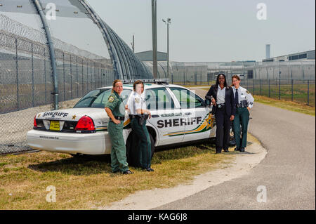 Four female deputies with the Hillsborough County Sheriff's Office standing in front of a patrol car at the jail facility in Brandon, Florida USA. Stock Photo