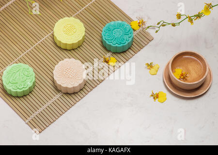 Sweet color of snow skin mooncake. Traditional mid autumn festival foods with tea on table setting. Stock Photo