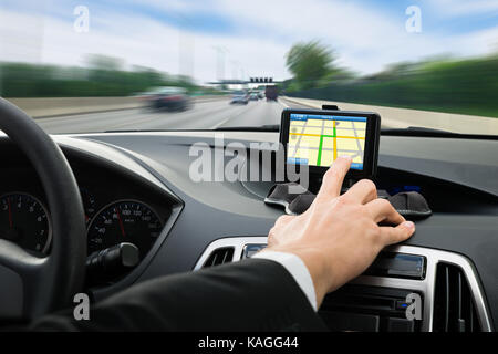 Close-up Of A Person's Hand Using Gps Navigation System In Car Stock Photo