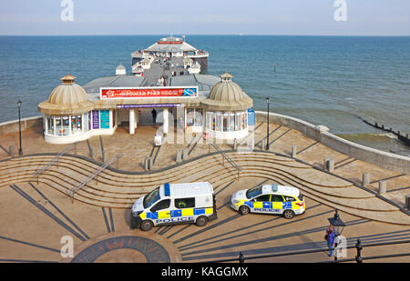 A view of the promenade and Pier with police presence at the North Norfolk resort of Cromer, Norfolk, England, United Kingdom. Stock Photo