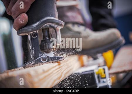 Wood Construction Power Tool. Wood Plank Cutting by Reciprocating Saw. Stock Photo