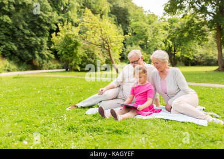 grandparents and granddaughter with tablet pc Stock Photo