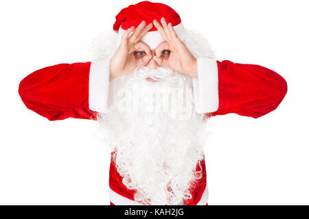 Portrait of Santa Claus looking through imaginary binocular isolated on white background Stock Photo