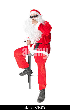 Santa Claus wearing sunglasses and smoking a cigar isolated on white background Stock Photo