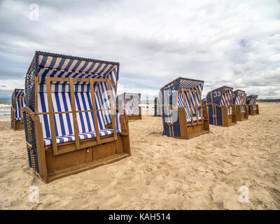 Empty roofed wicker beach chairs on sandy beach in Ustka resort, Baltic sea, Poland  clear sign that summer is over Stock Photo