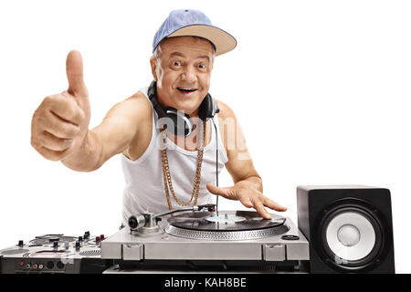 Elderly DJ playing music on a turntable and making a thumb up sign isolated on white background Stock Photo