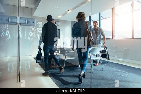 Business people walking in conference room. Group of people arriving at meeting in boardroom. Stock Photo