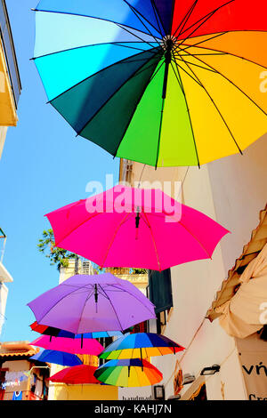 Akiathos, Greece. September 14, 2017.  Colorful parasols hanging on display outside a shop on a back street in Skiathos town on the Island of Skiathos Stock Photo