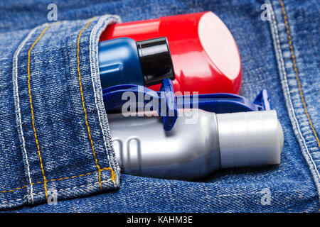 Antiperspirant deodorant, shaving cream, aftershave lotion and disposable razors in jeans pocket. Skin care cosmetic products and accessories for men Stock Photo