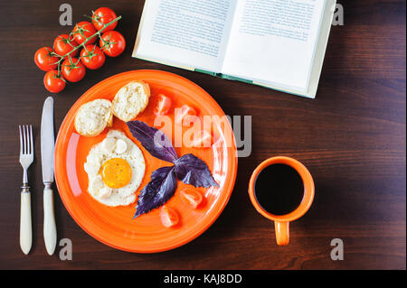 fried eggs mozzarella with basil and tomatoes on orange plate Stock Photo