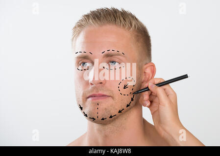 Close-up Of A Person's Hand Drawing Correction Line With Pen Stock Photo