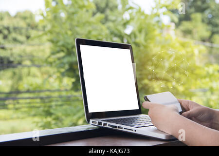 Woman hand used smart phone to find data on internet with blank screen of laptop, business concept Stock Photo