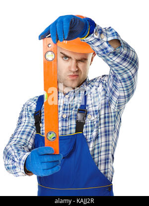 Young male construction worker checking the level with spirit level isolated on white background Stock Photo