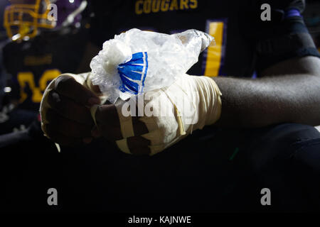 Philadelphia, PA, USA - October 4, 2013; Football player attends to injuries and discomforts at the sideline of a high school football game in Northwe Stock Photo