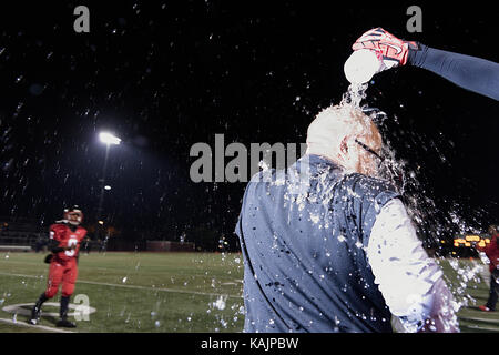 Philadelphia, PA, USA - November 15, 2013; An. High school football coach receives a celebratory shower after winning a city wide championships title, Stock Photo