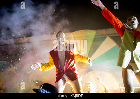 Male street festival performer dancing in front of a crowd of people with colorful background Stock Photo