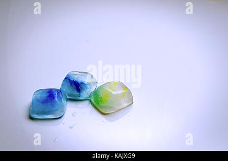 Ice cubes with food colouring on a white background Stock Photo