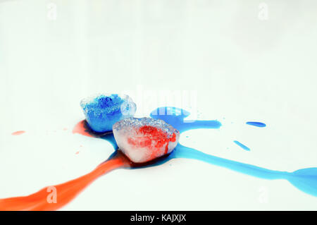 Ice cubes with food colouring on a white background Stock Photo