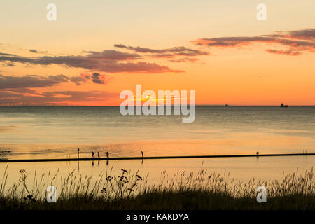 Walpole Bay.Cliftonville,Margate,Kent,UK. A family walking around a boatng pool in Walpole Bay at sunset. Stock Photo