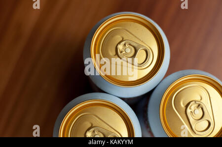 closeup photo of three beer cans on a wooden table Stock Photo