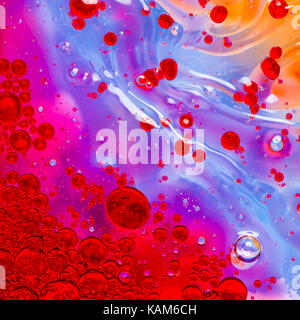 Abstract cluster of water-bubbles forming in front of a colourful blurry background Stock Photo