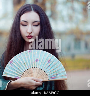 Portrait of young beautiful Asians in a grey kimono and with a fan Stock Photo