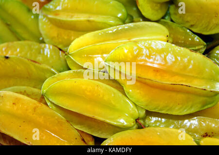 Delicious star fruit lay in cluster on table at Hilo's Farmers Market on the Big Island of Hawaii. Stock Photo