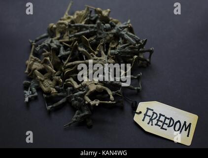 A pile of plastic toy soldiers with a tag that reads 'freedom'. Stock Photo