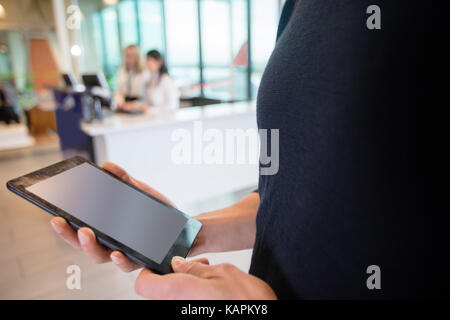 Midsection Of Male Passenger Using Digital Tablet At Airport Stock Photo