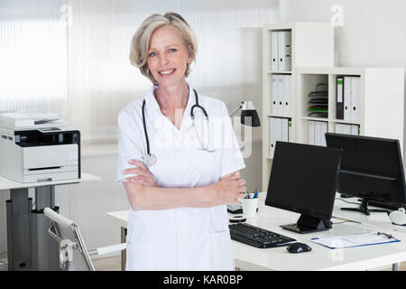 Portrait of confident female doctor standing arms crossed in clinic Stock Photo