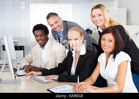 Portrait of multiethnic business people working at desk in office Stock Photo