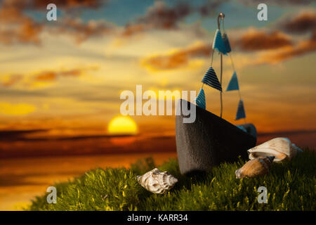 Small boat wit shells on the moss at sunset Stock Photo