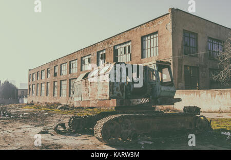 Abandoned excavator at an abandoned factory Stock Photo