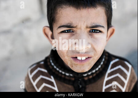 Portrait of a boy looking up at the camera in village Merzouga, Morocco Stock Photo