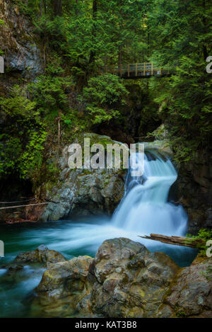 Twin Falls in Lynn Canyon Park with footbridge, North Vancouver, Canada. Long exposure. Stock Photo