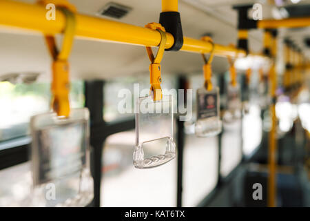 Handles for standing passenger inside a bus. Stock Photo