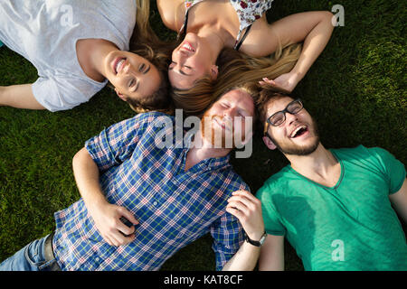 Happy students lying on ground and smiling Stock Photo