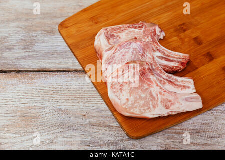 aw meat steak on dark wooden board. Thin slices of pork Stock Photo