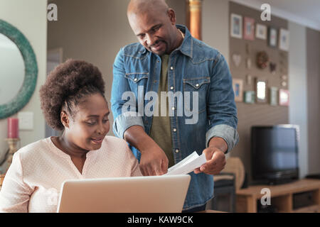 African couple paying bills online together at home Stock Photo