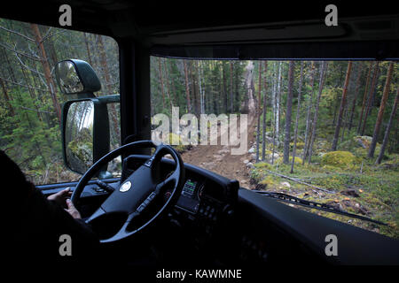 LAUKAA, FINLAND - SEPTEMBER 22, 2017: Looking down from top of the steep hill from the cabin of Scania defense vehicle during offroad driving in fores Stock Photo