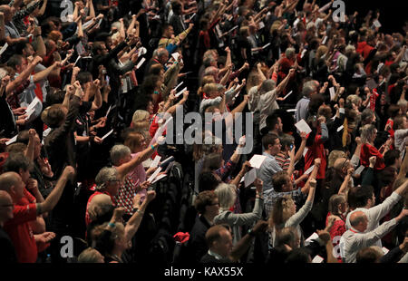 Delegates sing The Red Flag after Labour leader Jeremy Corbyn delivers his speech at the Labour Party annual conference at the Brighton Centre, Brighton. Stock Photo