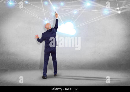 View of a Businessman in front of a wall with a Cloud network with net and connection - Technology concept Stock Photo