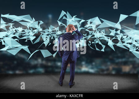 View of a Businessman in front of a wall with Abstract triangle displayed on a futuristic interface with line and points - Technology and connection c Stock Photo