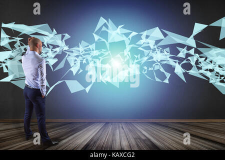 View of a Businessman in front of a wall with Abstract triangle displayed on a futuristic interface with line and points - Technology and connection c Stock Photo