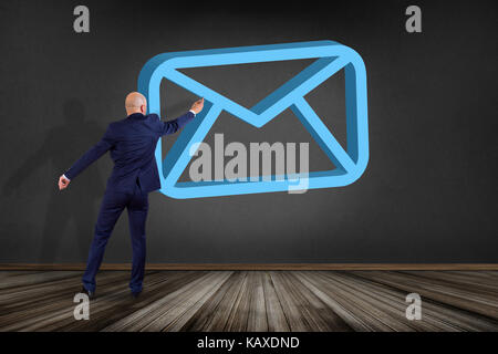 View of a Businessman in front of a wall with Blue Email symbol displayed on a futuristic interface - Message and internet concept Stock Photo