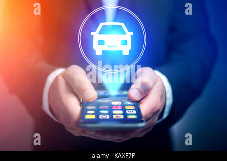View of Businessman hand holding mobile phone with car icon Stock Photo