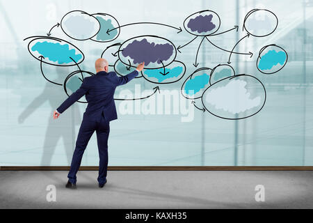 View of a Businessman in front of a wall writing on a business chart organization - Business concept Stock Photo
